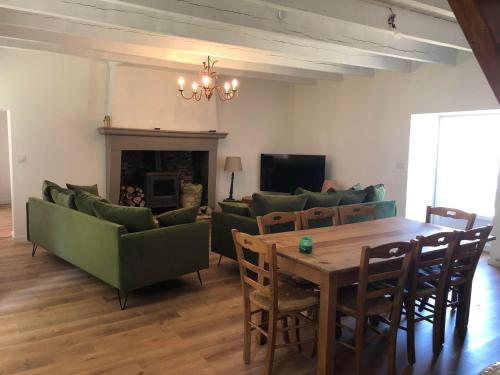 La Chapelle-Basse-MerにあるLa Ferme du domaine de La Mazureのリビングルーム(テーブル、椅子、暖炉付)