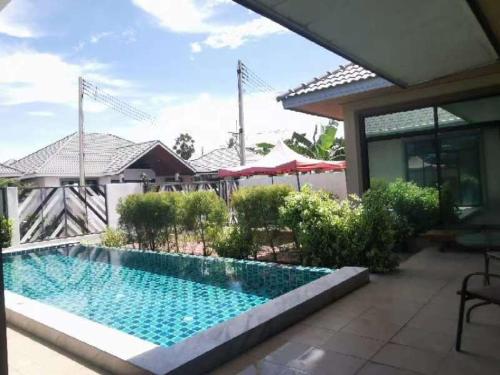 a swimming pool in front of a house at Modern Villa Hua Hin 华欣静家之泳池四合院 in Hua Hin