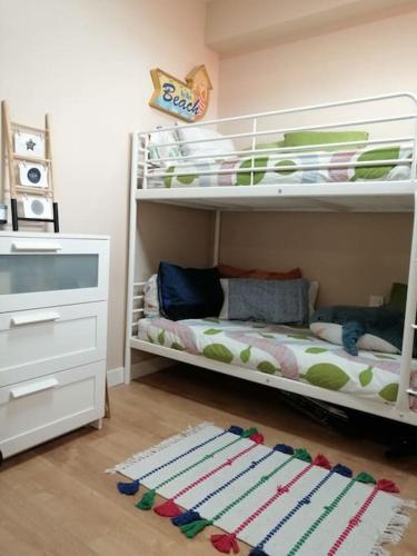 a childs bedroom with two bunk beds and a rug at Rías Baixas. Acogedor piso en la Ría de Arousa in Ribeira