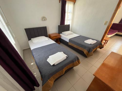 Habitación de hotel con 2 camas y toallas. en Ege Apartments, en Yalıkavak