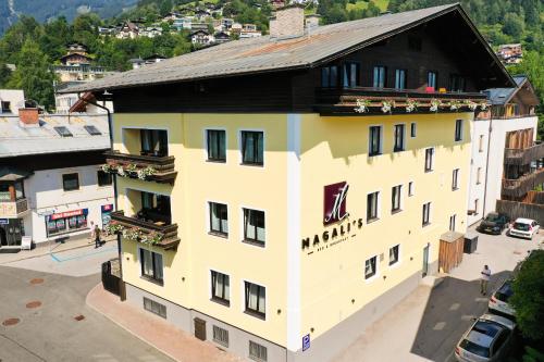 żółty budynek z czarnym dachem w obiekcie Magali's, Bed & Breakfast - former Pension Andrea w mieście Zell am See