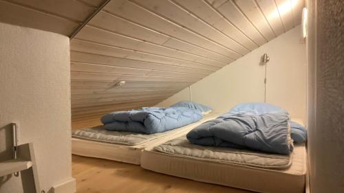two beds in a room with a wooden ceiling at Moderne sommerhus, 8 senge, 250 mtr til sandstrand in Slagelse