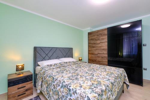 a bedroom with a large bed and a television at CroLos2 in Mali Lošinj