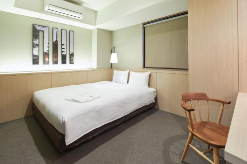 a bedroom with a bed and a chair and a chalkboard at Kyoto Itoya Hotel in Kyoto
