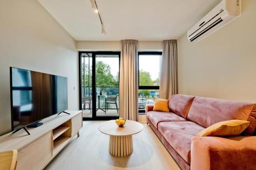 a living room with a couch and a tv at Apartamenty Wydma & Las BlueApart in Jastarnia