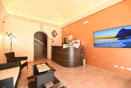 サン・ヴィート・ロ・カーポにあるBed & Breakfast Goccia Marinaのオレンジ色の壁のリビングルーム(薄型テレビ付)