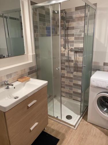 a bathroom with a shower and a sink and a washing machine at Isola d'Elba casa vacanze - Villa Portello - la casina bis - quarzo-pirite in Rio Marina