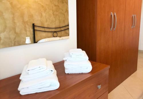 un mucchio di asciugamani seduti su un bancone in legno in bagno di Appartamenti Angelica 2 a Pisa