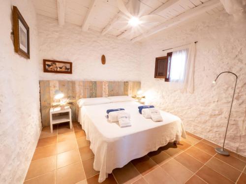 1 dormitorio con 2 camas, mesa y lámpara en Casa Piedra, en Cala Saona