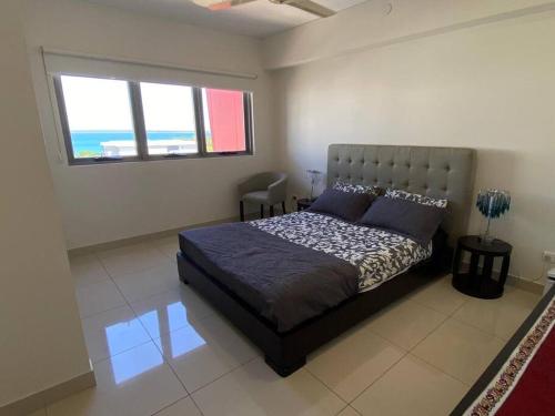 1 dormitorio con 1 cama grande y ventana en Katara On Smith - 2 Bed 2 Bath CBD Appartment, en Darwin