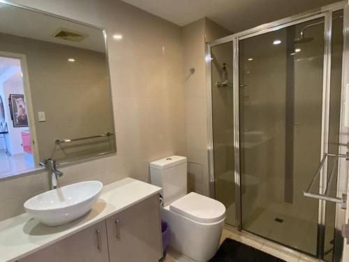 a bathroom with a toilet and a sink and a shower at Katara On Smith - 2 Bed 2 Bath CBD Appartment in Darwin