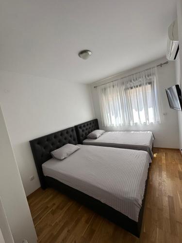 a bedroom with two beds and a window at APARTMAN RAFAILOVICI in Budva
