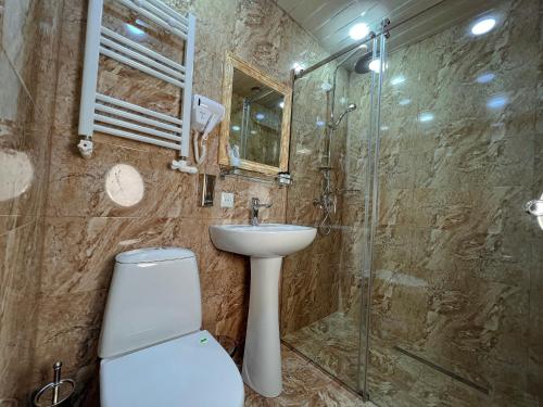 a bathroom with a toilet and a sink and a shower at Opera Avenue Hotel in Yerevan