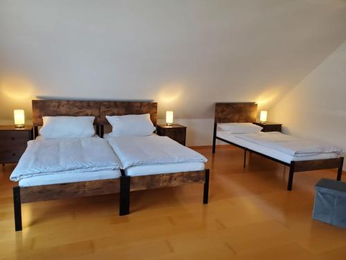 two beds in a room with two lamps on tables at Ferienwohnung Fröse in Altenbeken