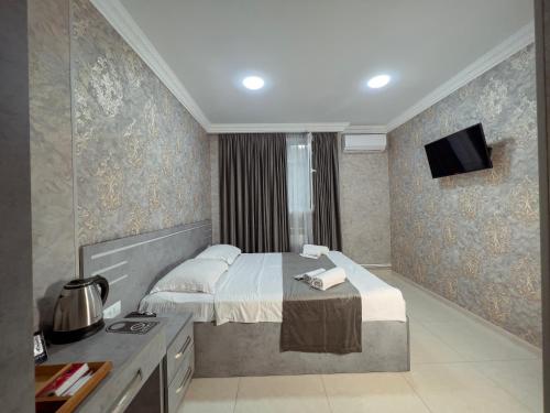 a hotel room with a bed and a tv at Opera Avenue Hotel in Yerevan