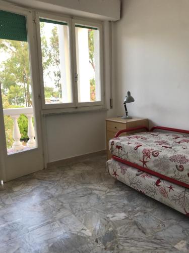 una camera con un letto e due finestre di Isola d'Elba casa vacanze - Villa Portello - la casina bis - quarzo-pirite a Rio Marina
