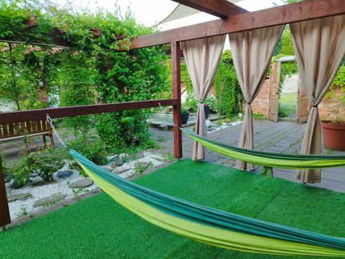 a hammock on a patio with green grass at Noclegi Szymrych in Chełmsko Śląskie