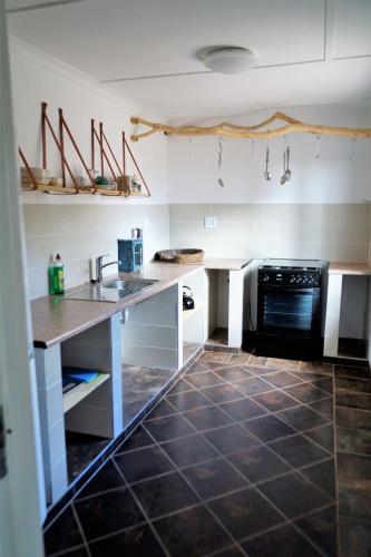 a kitchen with a sink and a stove at Halala Africa Lodge - Eagle Rock Lodge in Malabar