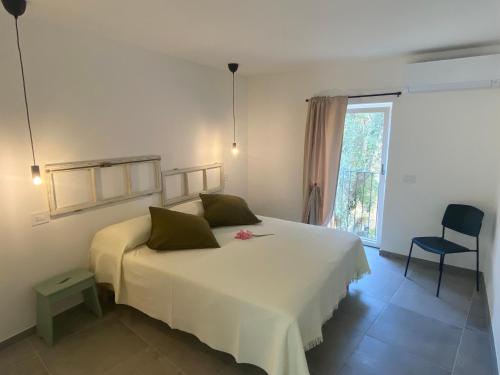 a bedroom with a large white bed and a window at Relais PINF in Malcesine
