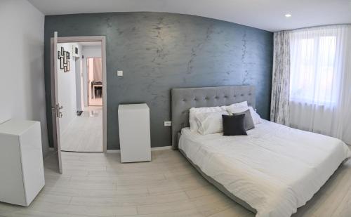 a bedroom with a bed and a blue wall at Acasă la Maria in Petrila