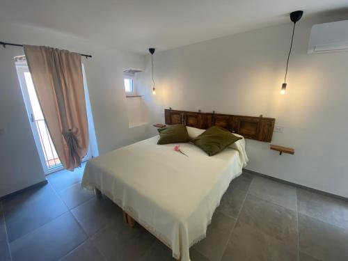 a bedroom with a white bed with green pillows at Relais PINF in Malcesine