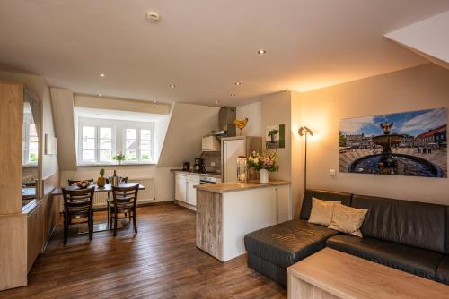 a living room and kitchen with a couch and a table at City-Appartements Am Wall in Goslar