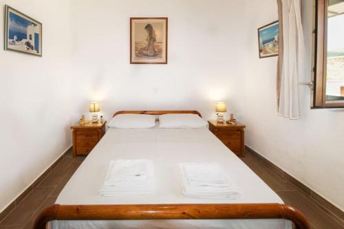 a bedroom with a large bed with two night stands at Stone house with Amazing View in Kótronas