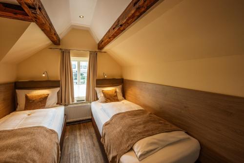 two beds in a room with a window at City-Appartements Am Wall in Goslar