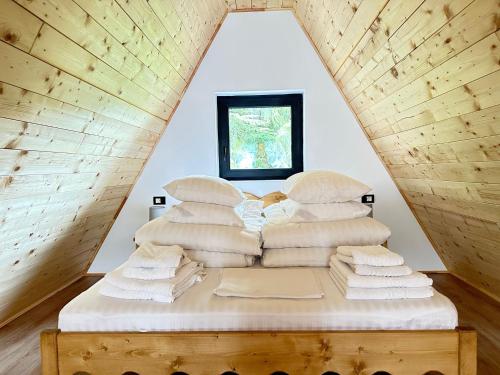 ein Bett mit weißen Decken und Kissen im Dachgeschoss in der Unterkunft A Frame Chalet By Superski in Cavnic