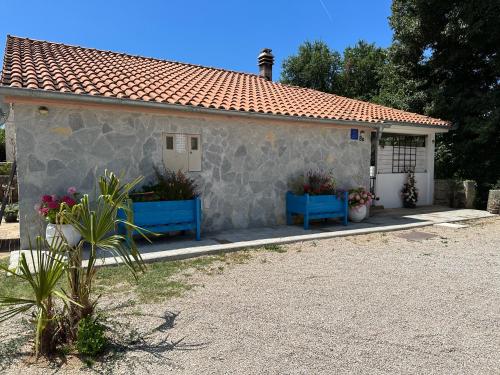 a house with two blue benches in front of it at Casa Mio in Malinska
