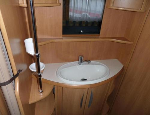 un bagno con lavandino e finestra in un camper di Olga caravane ad Aywaille