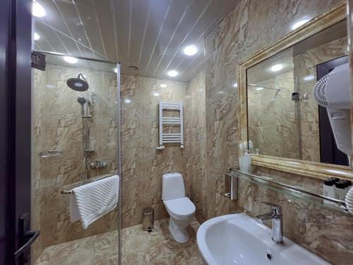 a bathroom with a toilet and a sink and a shower at Opera Avenue Hotel in Yerevan