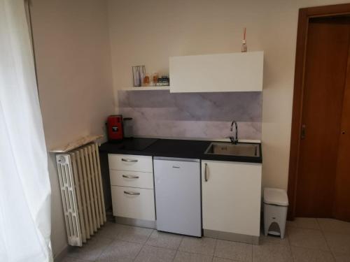 eine kleine Küche mit weißen Schränken und einem Waschbecken in der Unterkunft D&V MAISON in Potenza