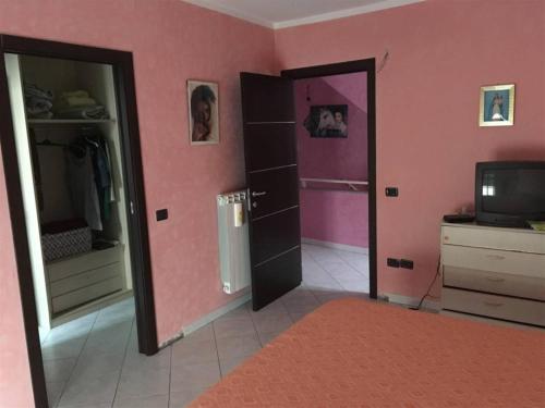 Vallefiorita的住宿－La Piccola Valle，粉红色的房间,设有两个开放式的门和电视