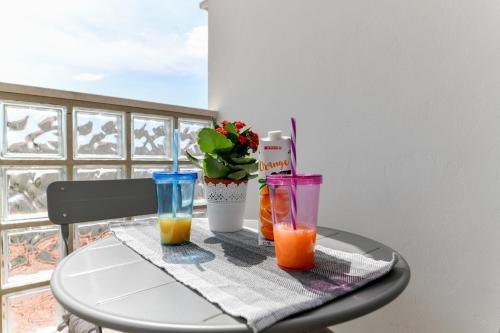 un tavolo con tre bicchieri su un tavolo con un tavolo di Sunset Puntamika a Zara (Zadar)