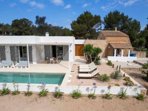 a villa with a swimming pool and a house at Casa Casita in Cala Saona