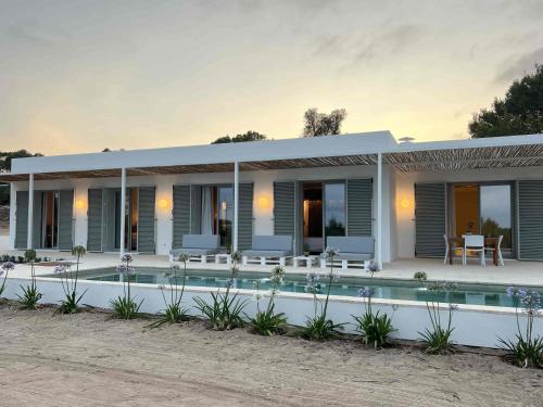 a villa with a swimming pool at dusk at Casa Casita in Cala Saona