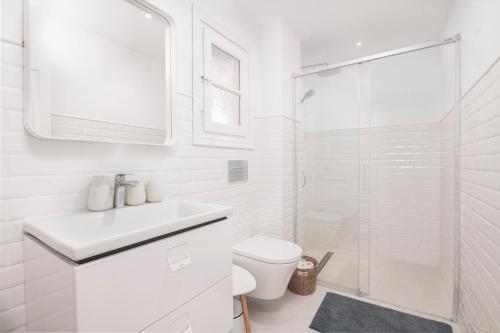 y baño blanco con lavabo y ducha. en El Portet Moraira Apartment Ella, en Moraira