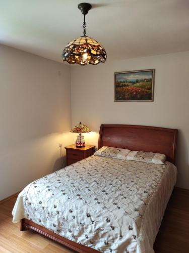 Schlafzimmer mit einem Bett und einem Kronleuchter in der Unterkunft Уютные апартаменты - 400 метров от пляжа in Sutomore