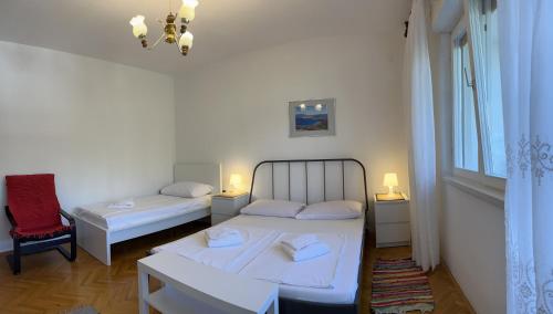 a small room with two beds and a window at Apartment Sersic in Baška