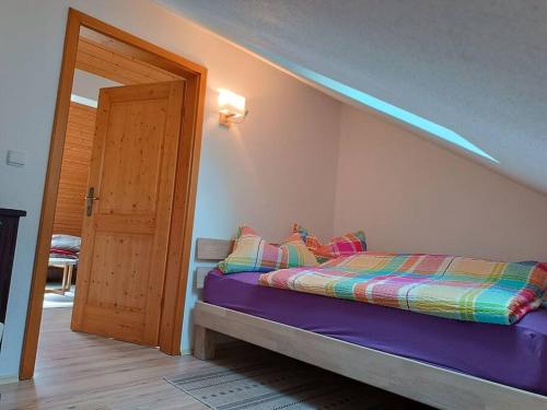 a bedroom with a bed with a purple comforter at Ferienwohnung - Dachgeschoss Schmuckstück in Wolnzach
