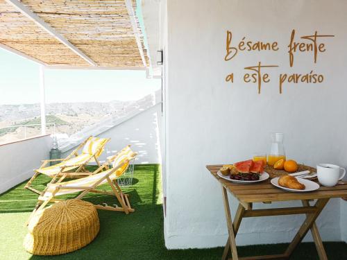 een balkon met een tafel met een fruitschaal bij Las Pizarrillas: tu hogar en este blanco pueblo in Frigiliana