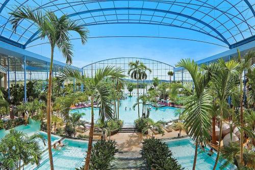 an indoor resort with a pool and palm trees at Ferienwohnung Morenz in Sinsheim