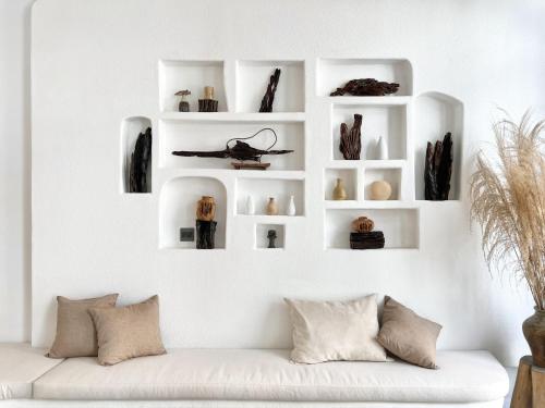 a white living room with a white couch at La Grotta Hotel - Phu Quoc Emerald Bay in Phu Quoc