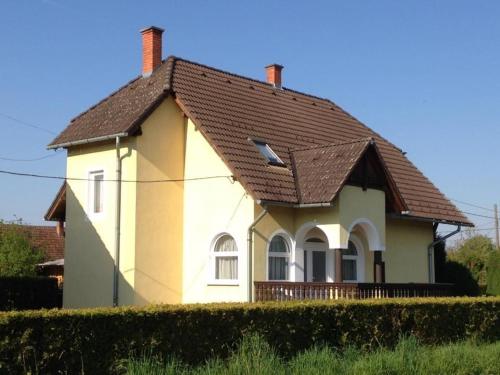 une maison blanche avec un toit marron dans l'établissement Erdőgyöngye Vendégház CSÖDE, à Csöde