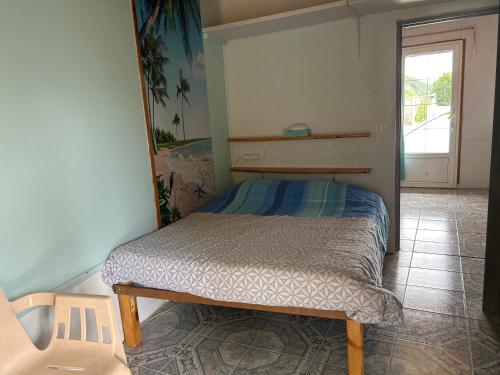 a small bed in a room with a chair at 2 à 4 pers appartement dans Maisonnette piscine chambre double salle de bain privatif in Saint-Amarin