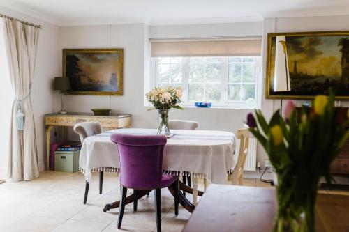 a dining room with a table and purple chairs at Castle Lodge in Pembrokeshire