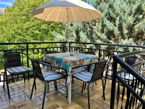 a table with chairs and an umbrella on a balcony at Apartment Sersic in Baška
