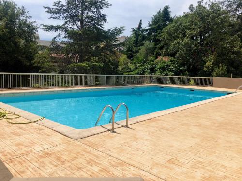 une piscine avec de l'eau bleue dans une cour dans l'établissement Appartement neuf, piscine, terrasse, vue mer., à Cannes