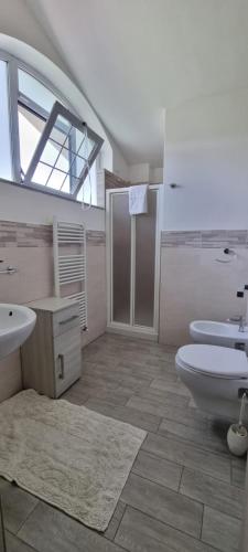 a large bathroom with two sinks and a toilet at Villa Naclerio in Sarzana